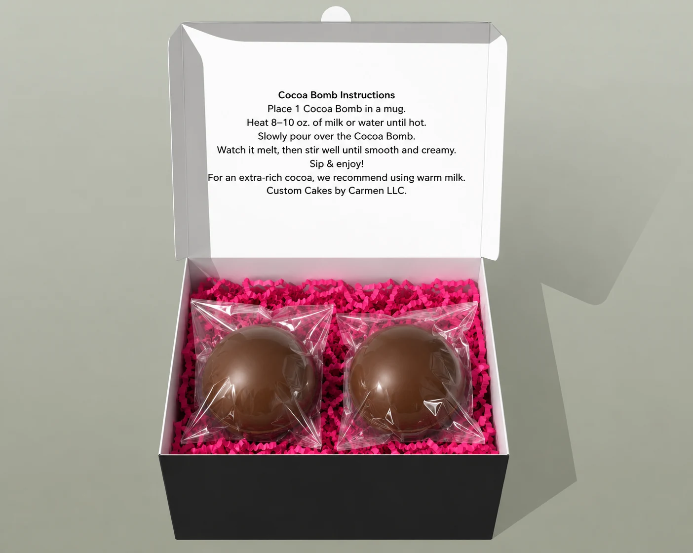 Two handcrafted chocolate confections presented in a gift box with signature pink details